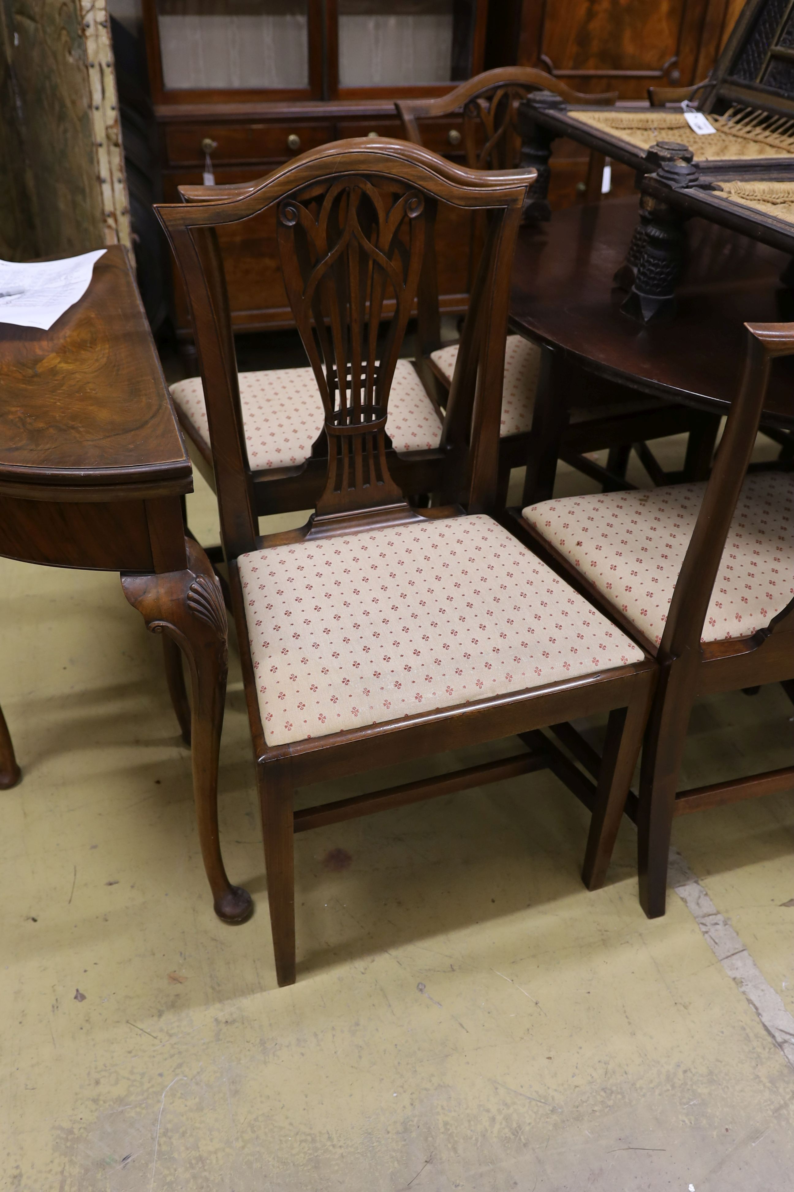 A set of nine George III and later mahogany dining chairs with pierced splats and upholstered drop in seats (six antique three reproductions, one with arms)